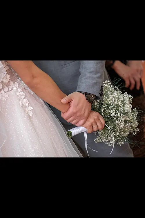 Color wedding photo by Lucas Georgiev. Hands being together with the bouquet. Place: Lovech, Bulgaria